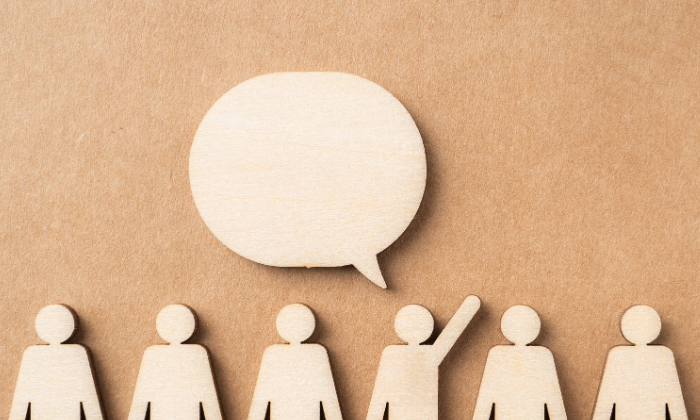 A person with their hand up to ask a question