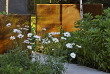 The perforated steel lends a lightness to the structural panels and a visual continuity of the planting is maintained.